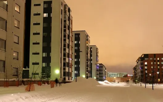 Kuvassa luminen katu kerrostalojen välissä. 