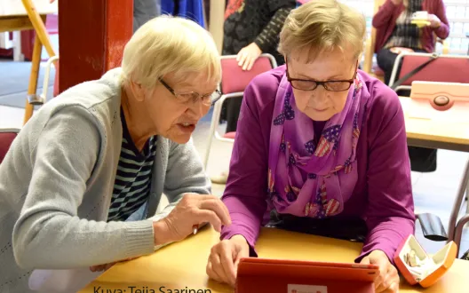 Opastaja ja opastettava tutkivat yhdessä tabletin mahdollisuuksia.