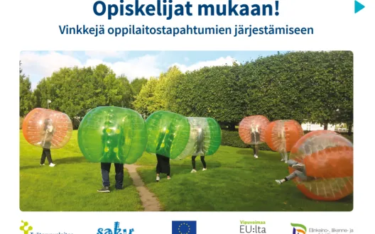 Ihmiset leikkivät kuplapalloilla nurmialueella.