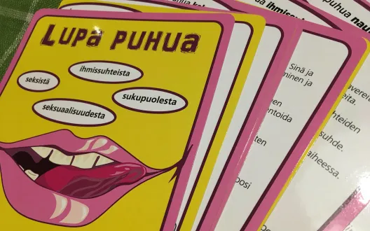Kuvassa on korttipakka, jonka päällimmäisessä kortissa punaiset, flirttailevat huulet keltaisella pohjalla sekä teksti: Lupa puhua seksistä, ihmissuhteista, seksuaalioikeuksista, sukupuolesta.