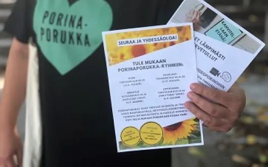 Nainen pitää kädessään esitteitä.