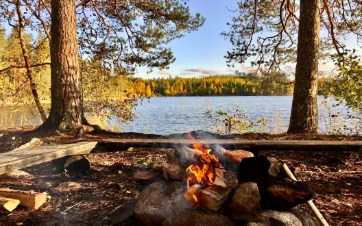 Kuva nuotiosta järven rannalla