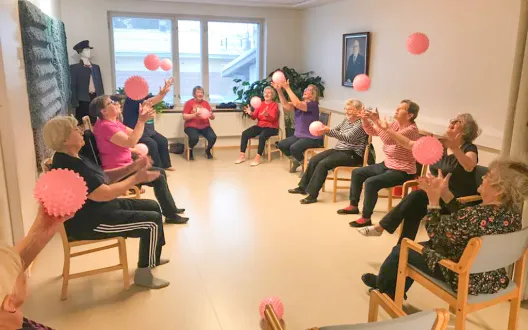 Ihmisiä tuolissa istumassa