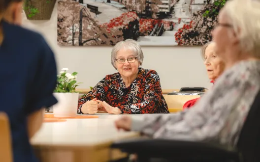 Ikääntyneet keskustelevat pöydän äärellä