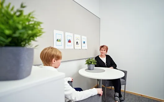kuvassa nainen ja lapsi pöydän äärellä keskustellen