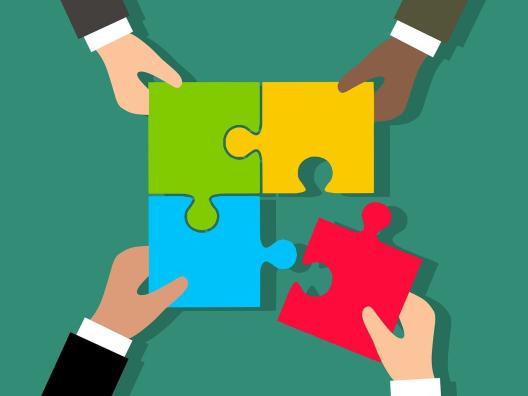 Ihmiset kokoavat yhdessä palapeliä