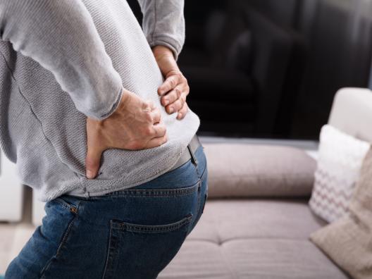 Mies pitelee kipeää selkäänsä