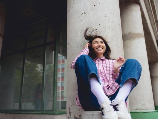 tyttö istuu ja hymyilee