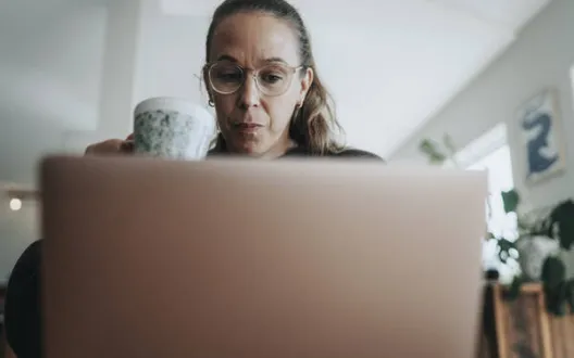 Nainen kannettavan tietokoneen äärellä