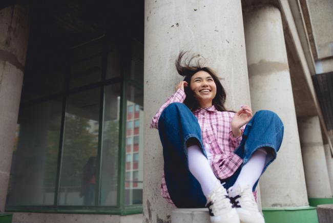 tyttö istuu ja hymyilee