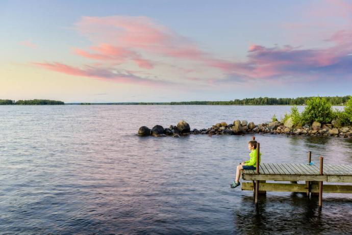Henkilö istuu laiturin päässä